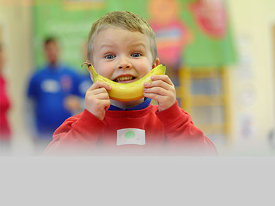 Boy eats banana as white goods and breakfasts provided to disadvantaged families